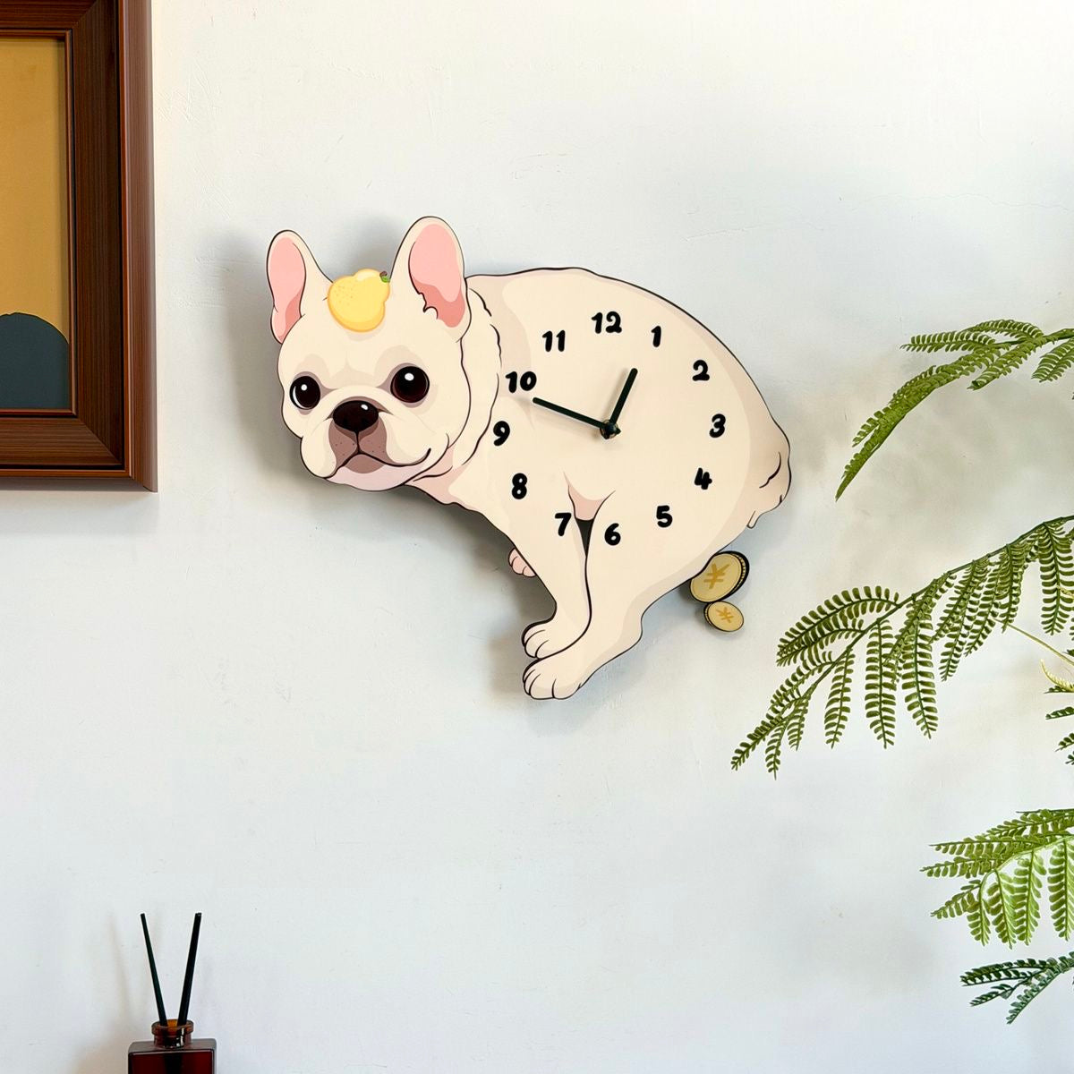 Cream Frenchie pendulum wall clock — lifestyle on wall with plant